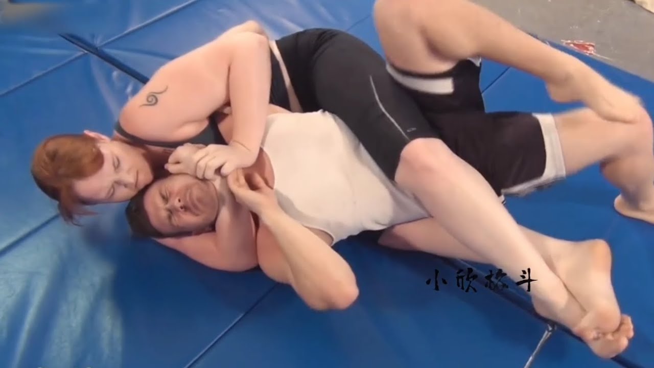 Woman Applying a Rear Naked Choke on Man​Mixed Grappling Submission Hold