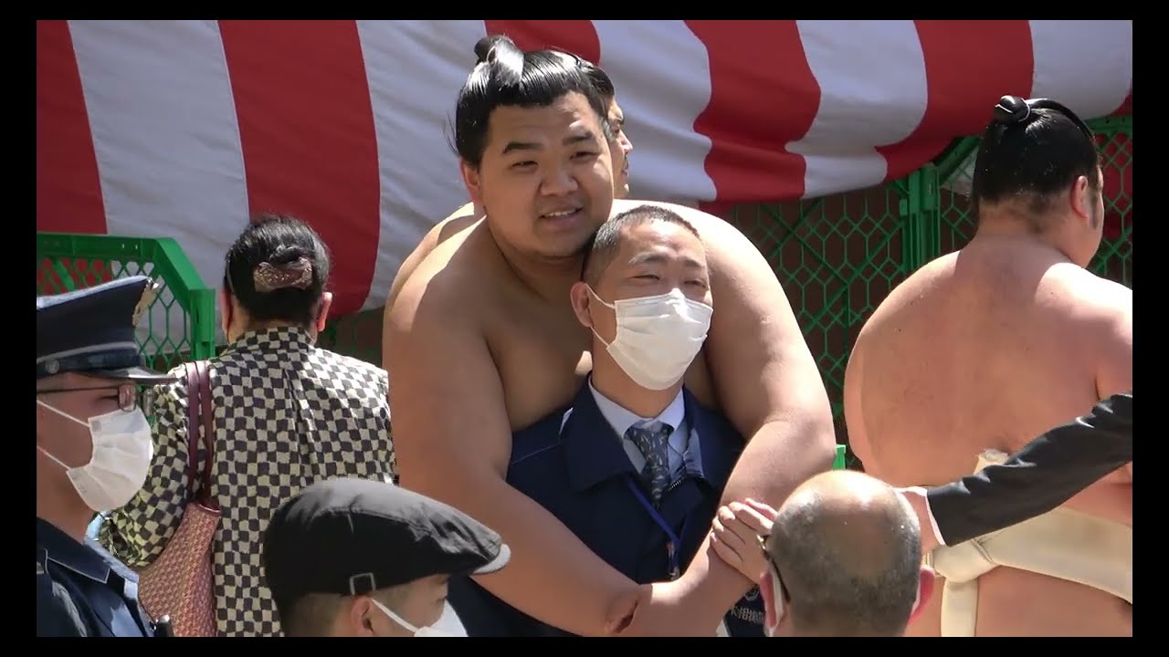 Laughing Terunofuji and the men behind the masks background