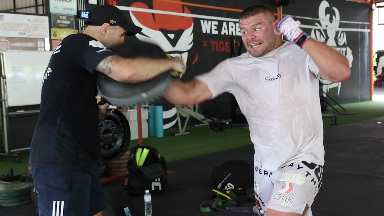 ONE Championship heavyweight title contender Anatoly Malykhin hitting mitts with John Hutchinson background
