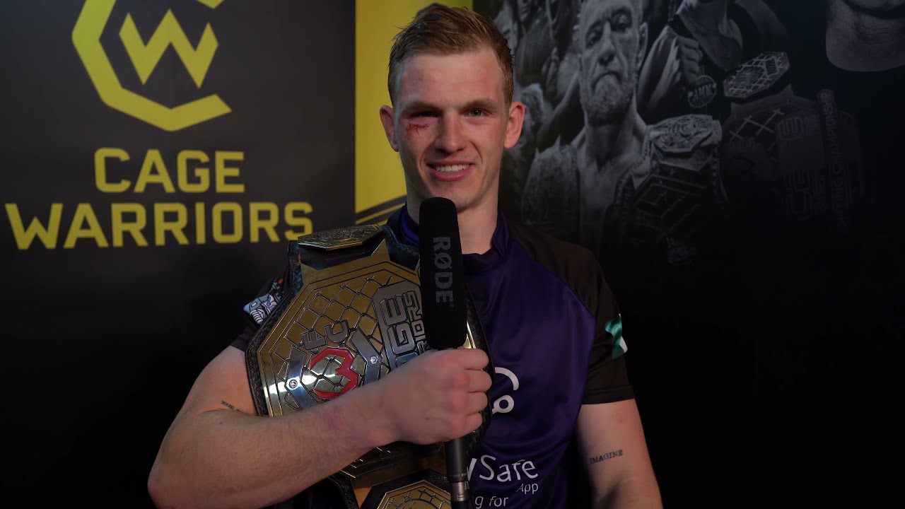 Ian Garry speaks to Edith Labelle after winning the welterweight title at #CW125 background