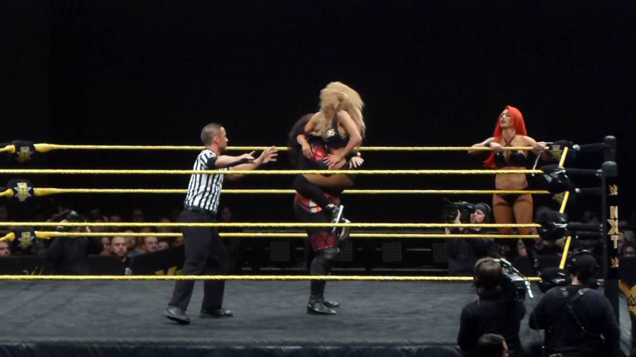 Eva Marie and Nia Jax vs Carmella and Bayley at NXT LIVE background
