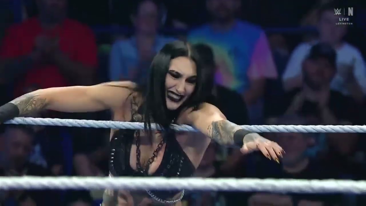 Rhea Ripley & Charlotte Flair Vs The Fatal Influence, Jade Cargill, Michin, & B Fab attack background