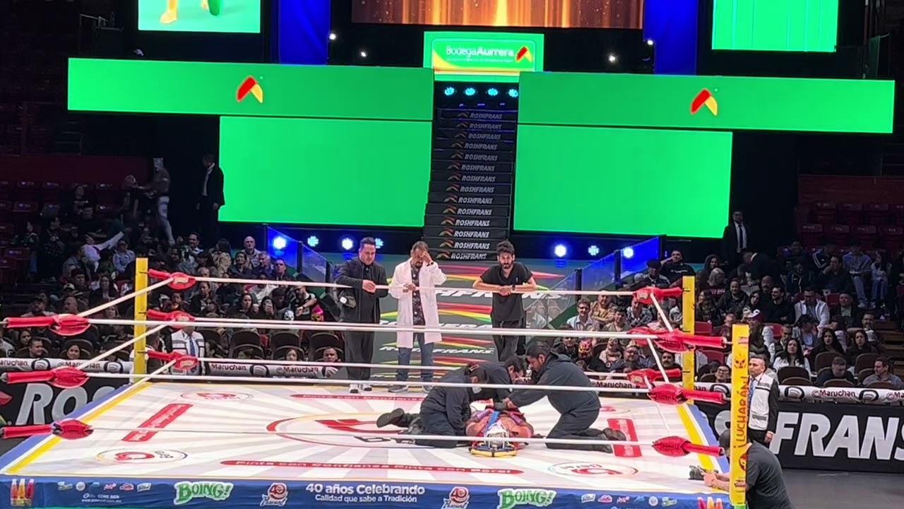 Luego de un poderoso azotón sobre la lona, Kimba es retirado en camilla del ring de la Arena México background